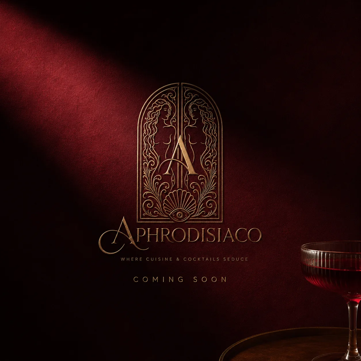 Gold Aphrodisiaco logo and coming soon message on a dark red background